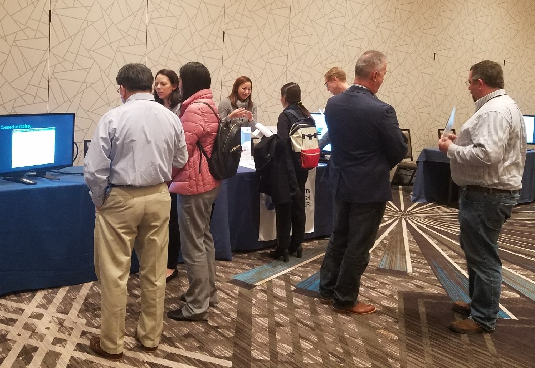 Britnee Johnston talking to people at a kiosk booth.